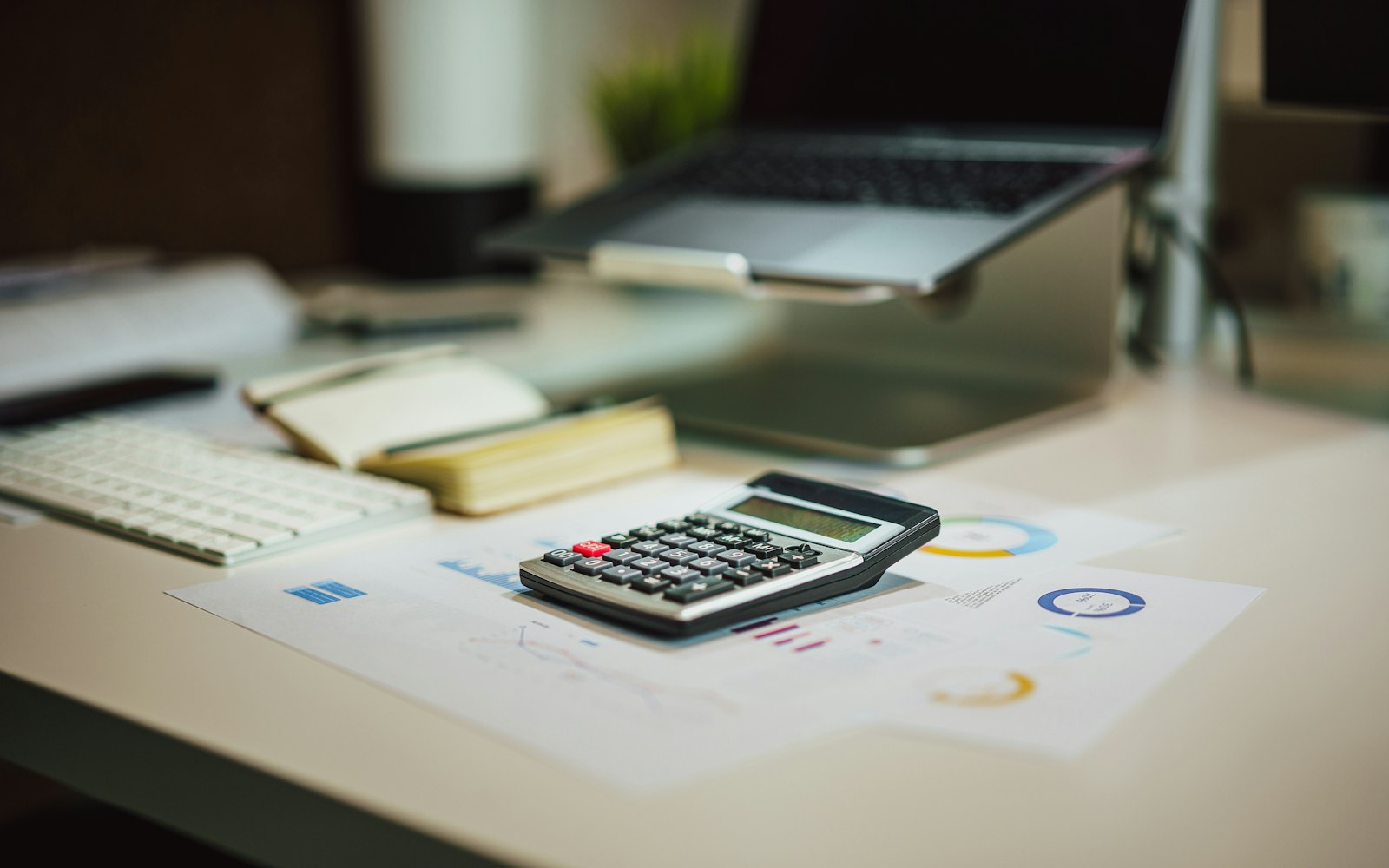 Calculatrice et documents chiffrés sur un bureau devant un ordinateur